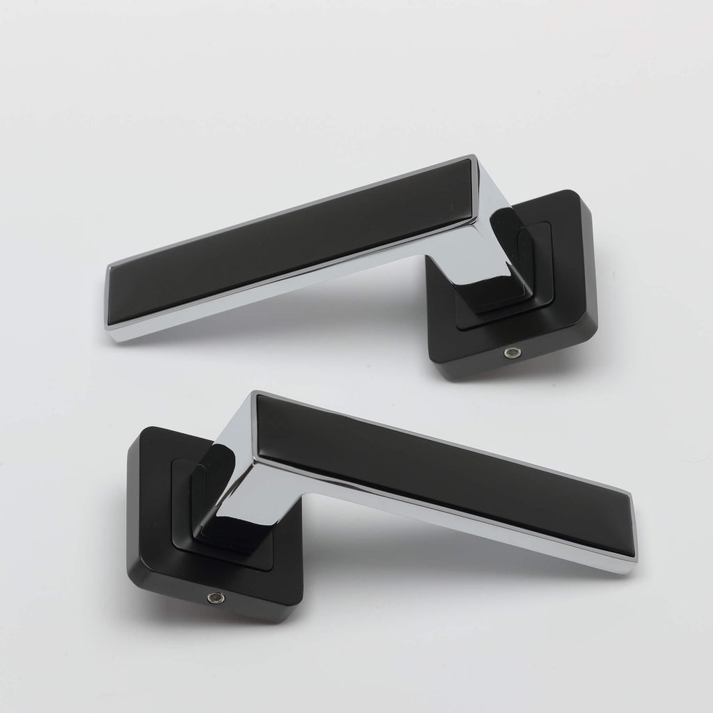 A pair Alto flat black & chrome plated square rose door handles on a white background.