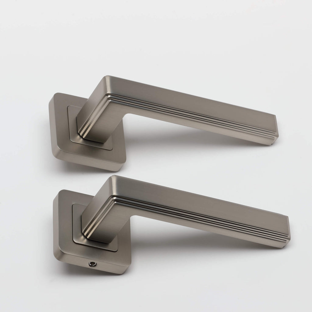 A side view of a pair of Ares Matt Satin Nickel Square Rose door handles on a white background