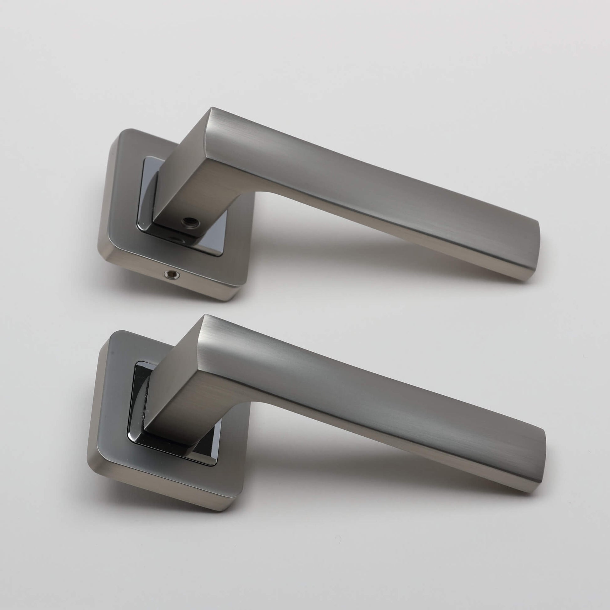 A side view of an Artemis Matt Satin Nickel & Polished Chrome Square Rose door handle on a light grey background.