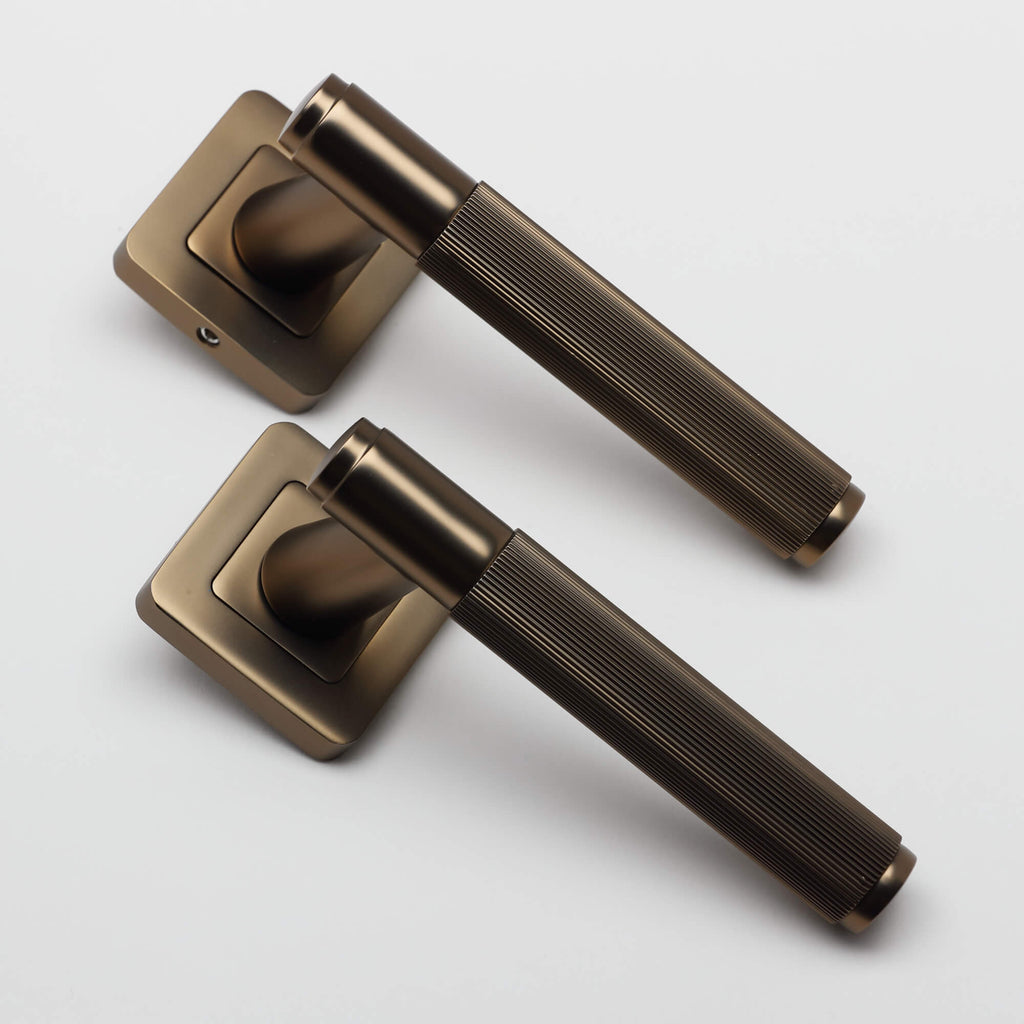 A angled view of a pair of Athena Hermes Matt Coffee Square Rose Handles on a white background.