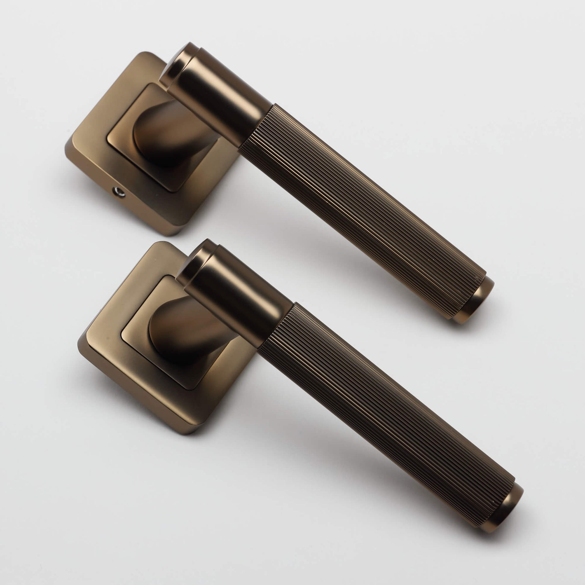 A angled view of a pair of Athena Hermes Matt Coffee Square Rose Handles on a white background.