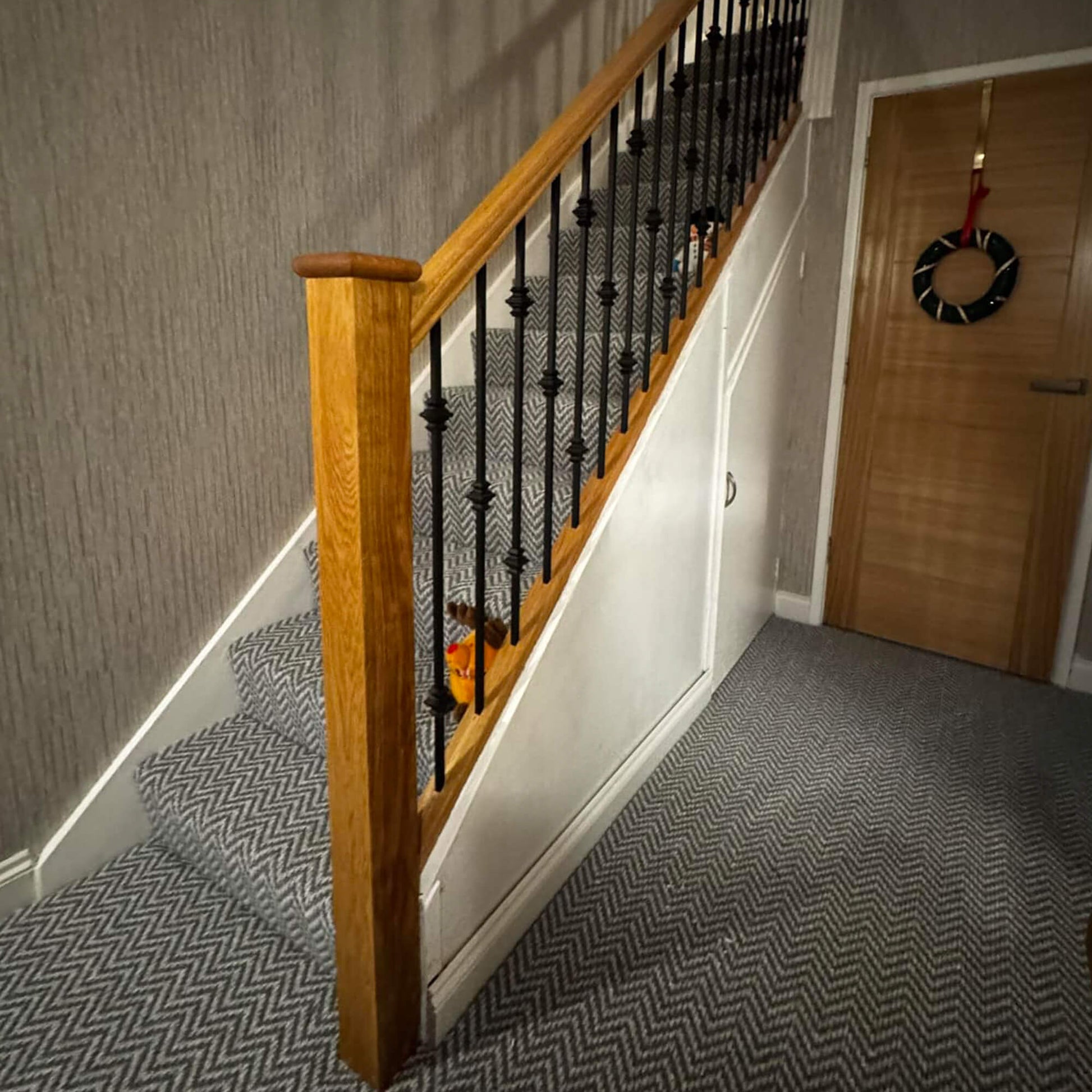 Oak Staircase with Black Knuckle Spindles in a home interior.
