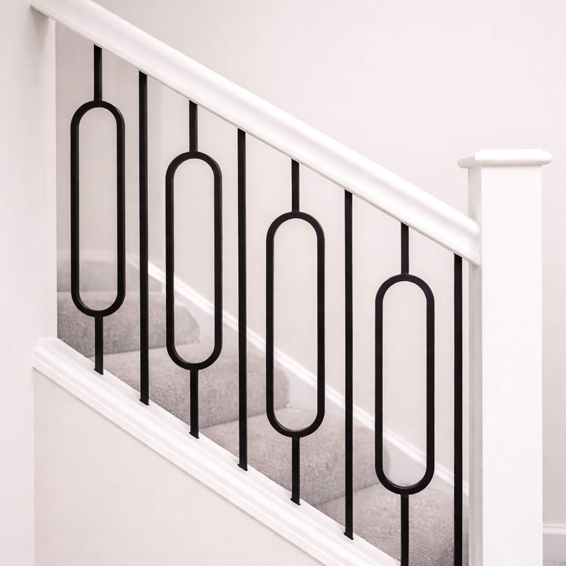 Close-up of Black Oval Spindles on a White Primed Staircase with a blank newel post
