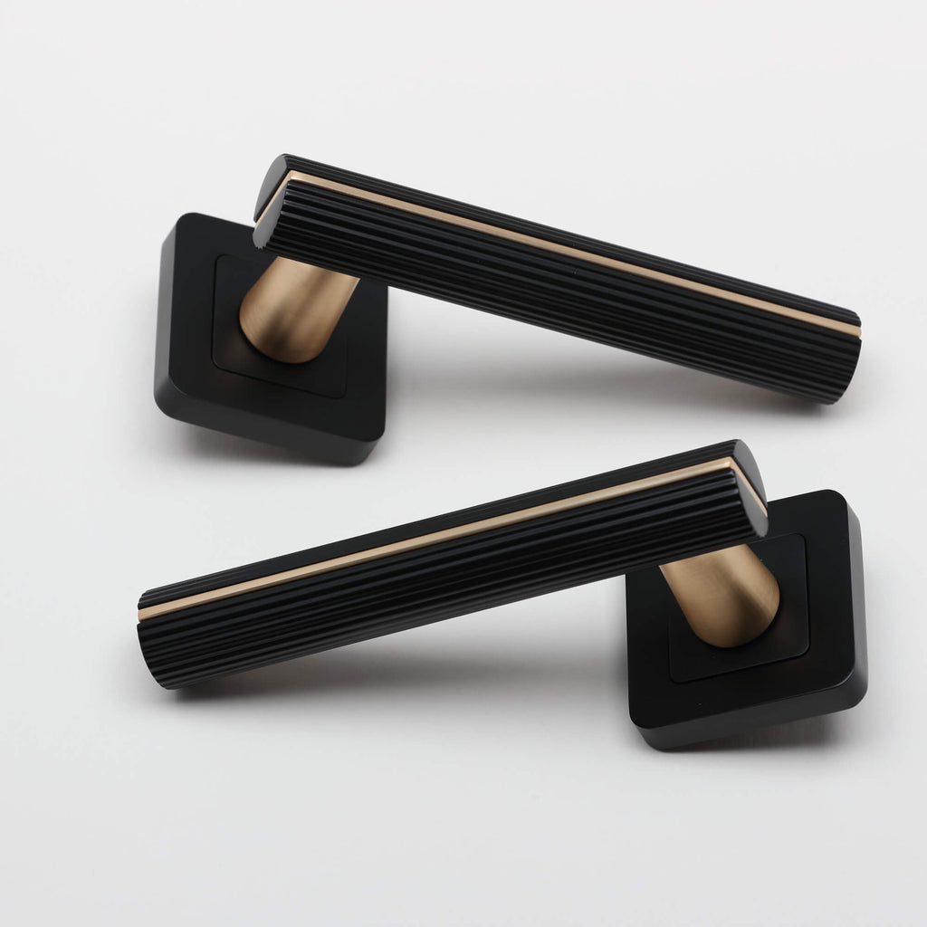 A pair of Calvus Flat Black & Satin Brass Square Rose Handles on a light grey background.