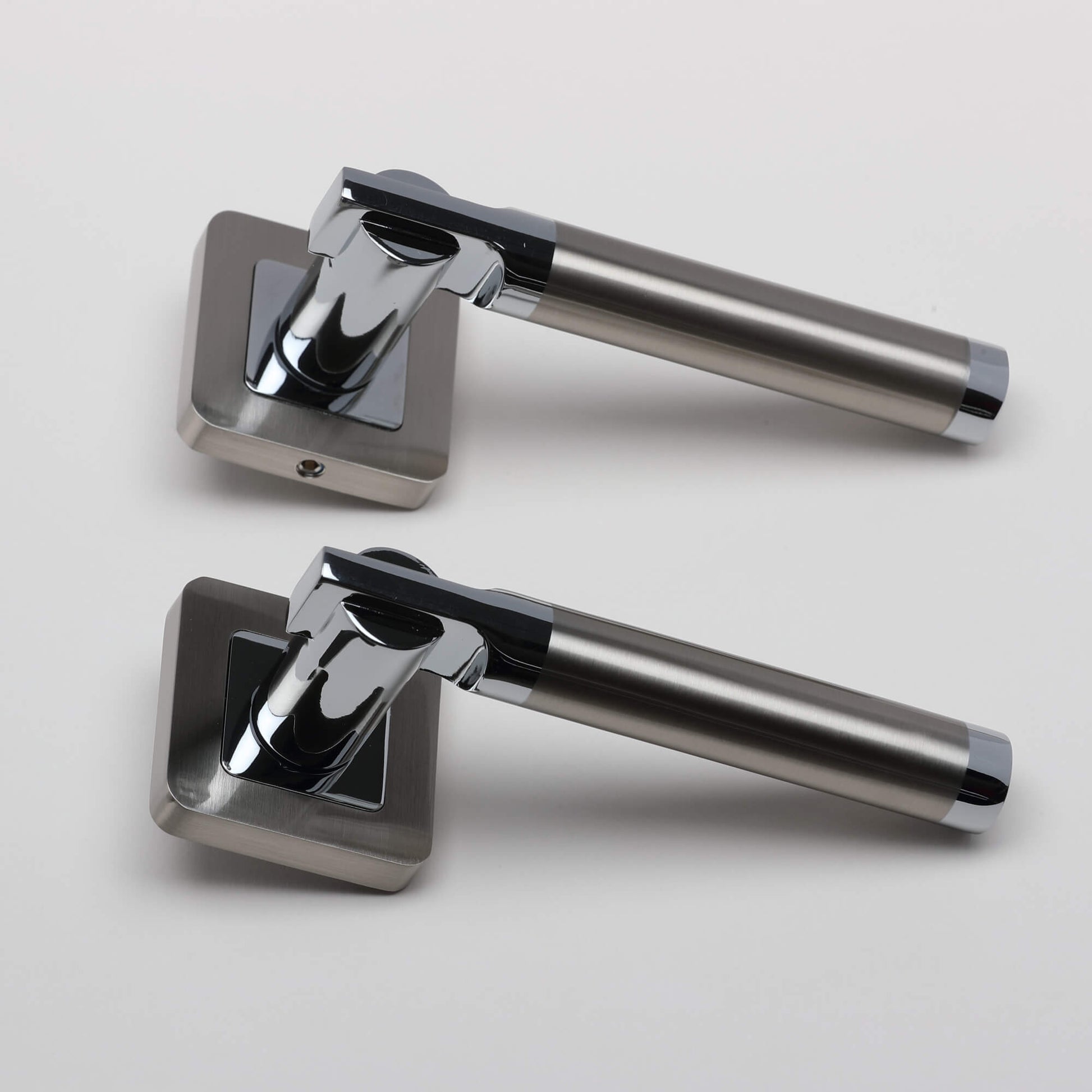A side view of a pair of Cumulus Nickel Brushed & Polished Chrome Square Rose Handles on a light grey background.