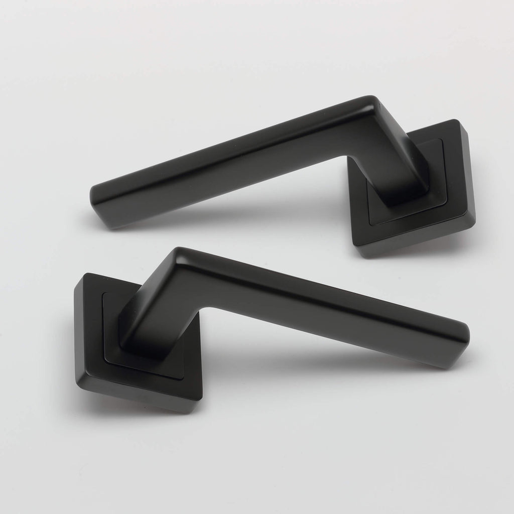 A pair of Hera Flat Black Square Rose door handles on a light grey background.