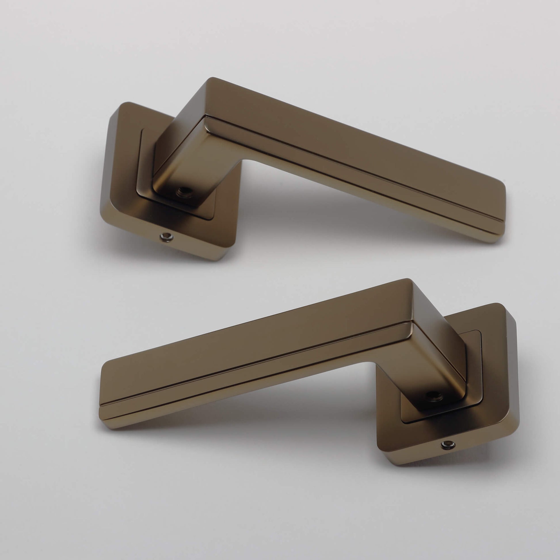 A pair of Hermes Matt Coffee Square Rose Handles on a grey background.