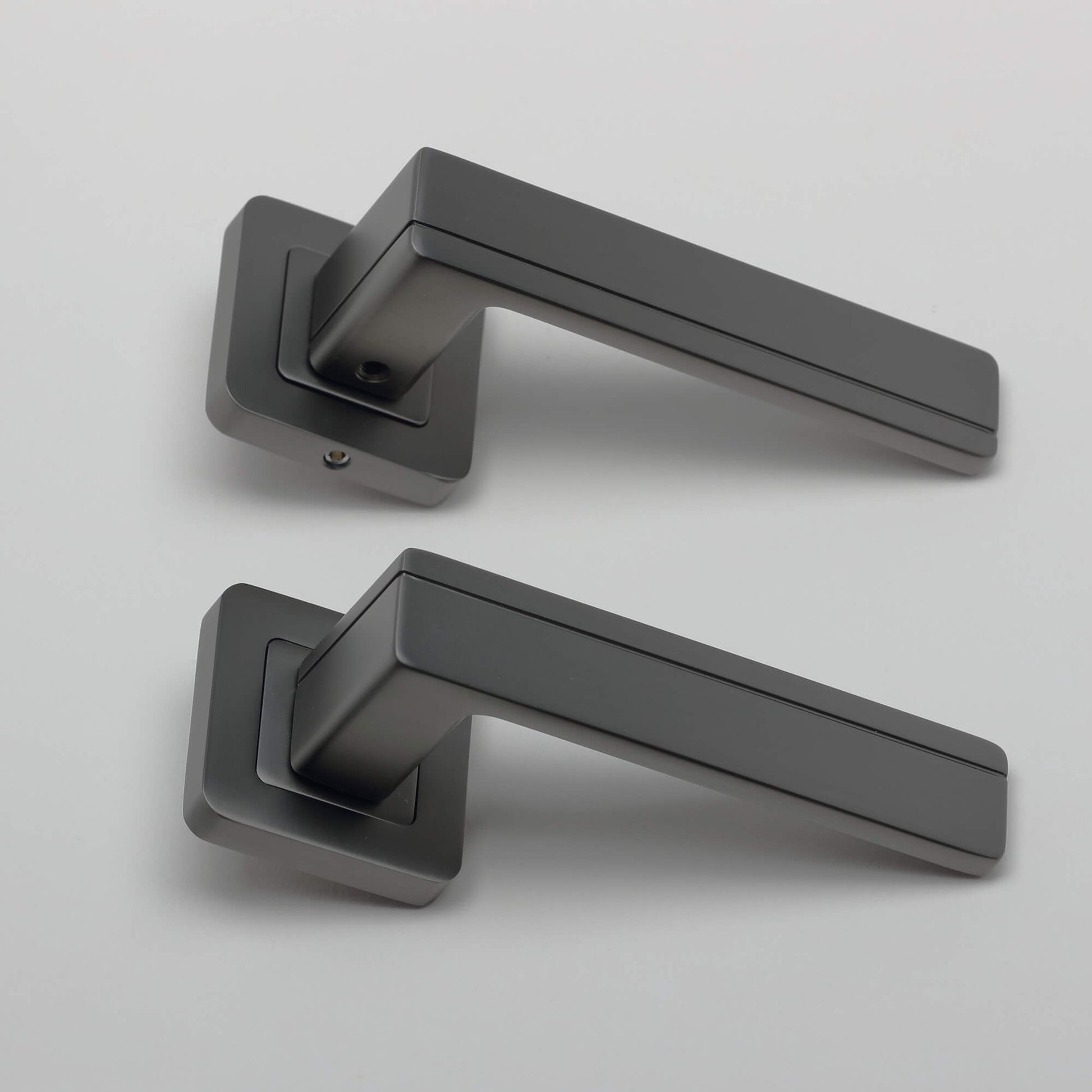 A side view of a pair of Hermes Matt Satin Black Square Rose Handles on a light grey background.
