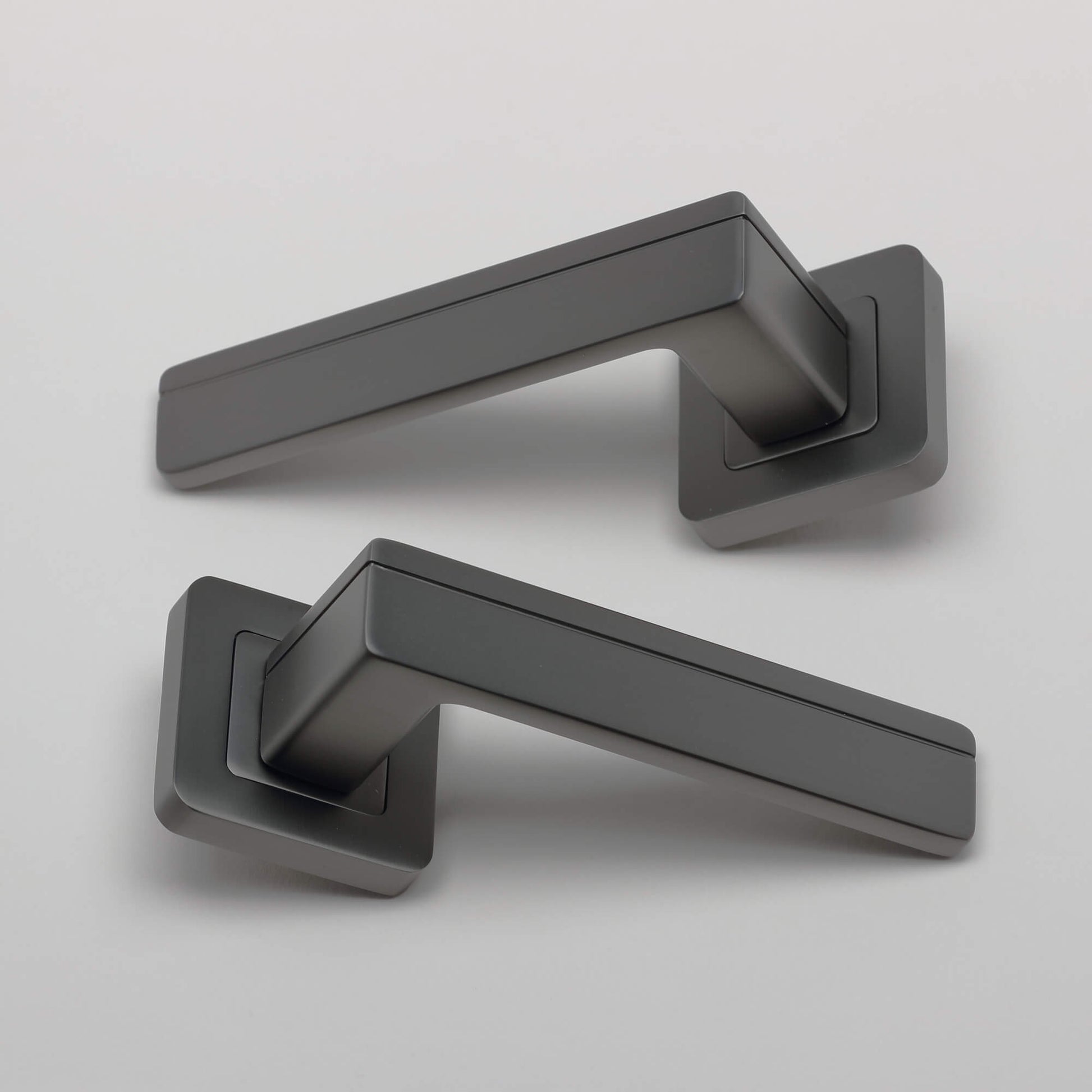 A pair of Hermes Matt Satin Black Square Rose Handles on a light grey background.