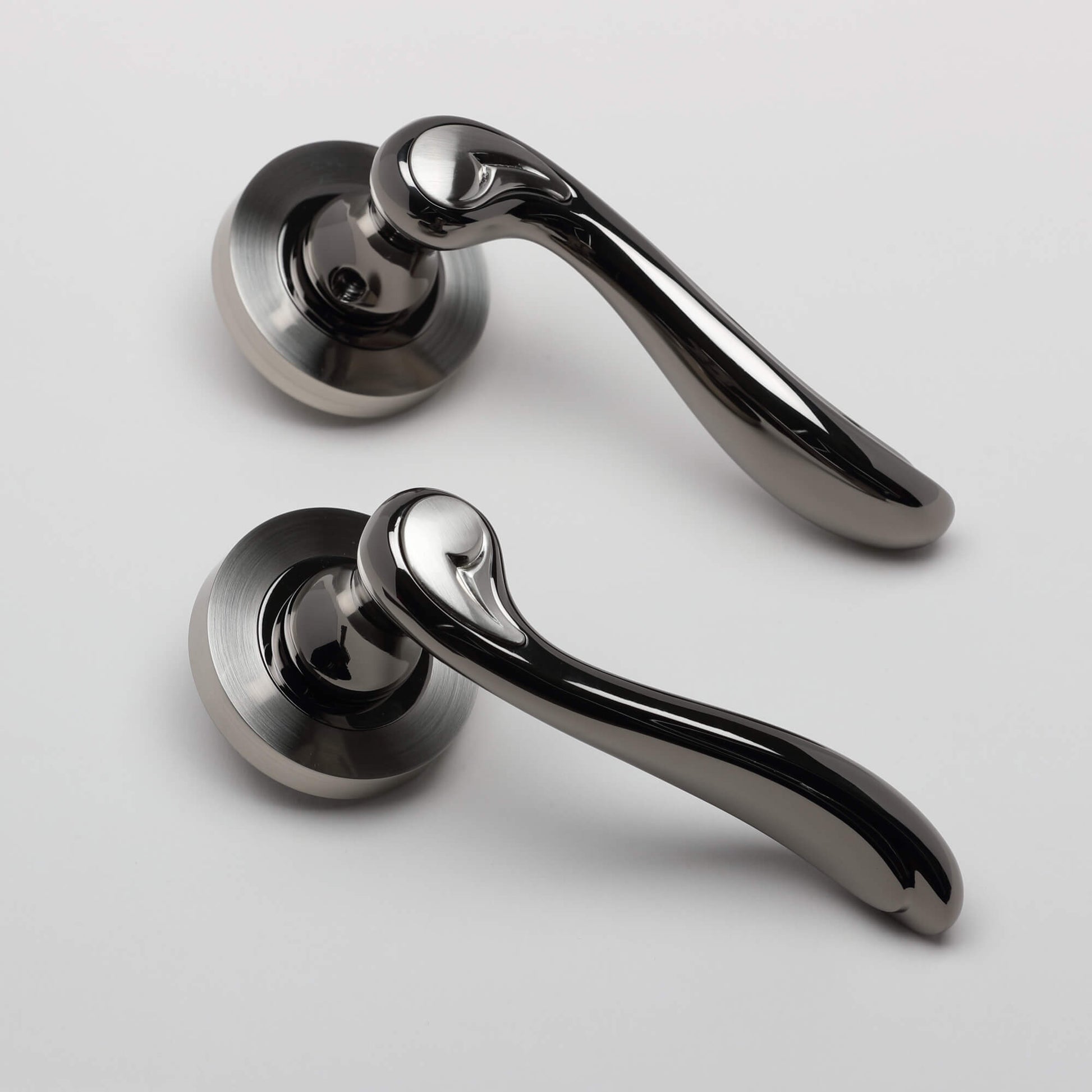 A pair of Monet Black Nickel & Nickel Brushed Round Rose Door Handle on a white background.