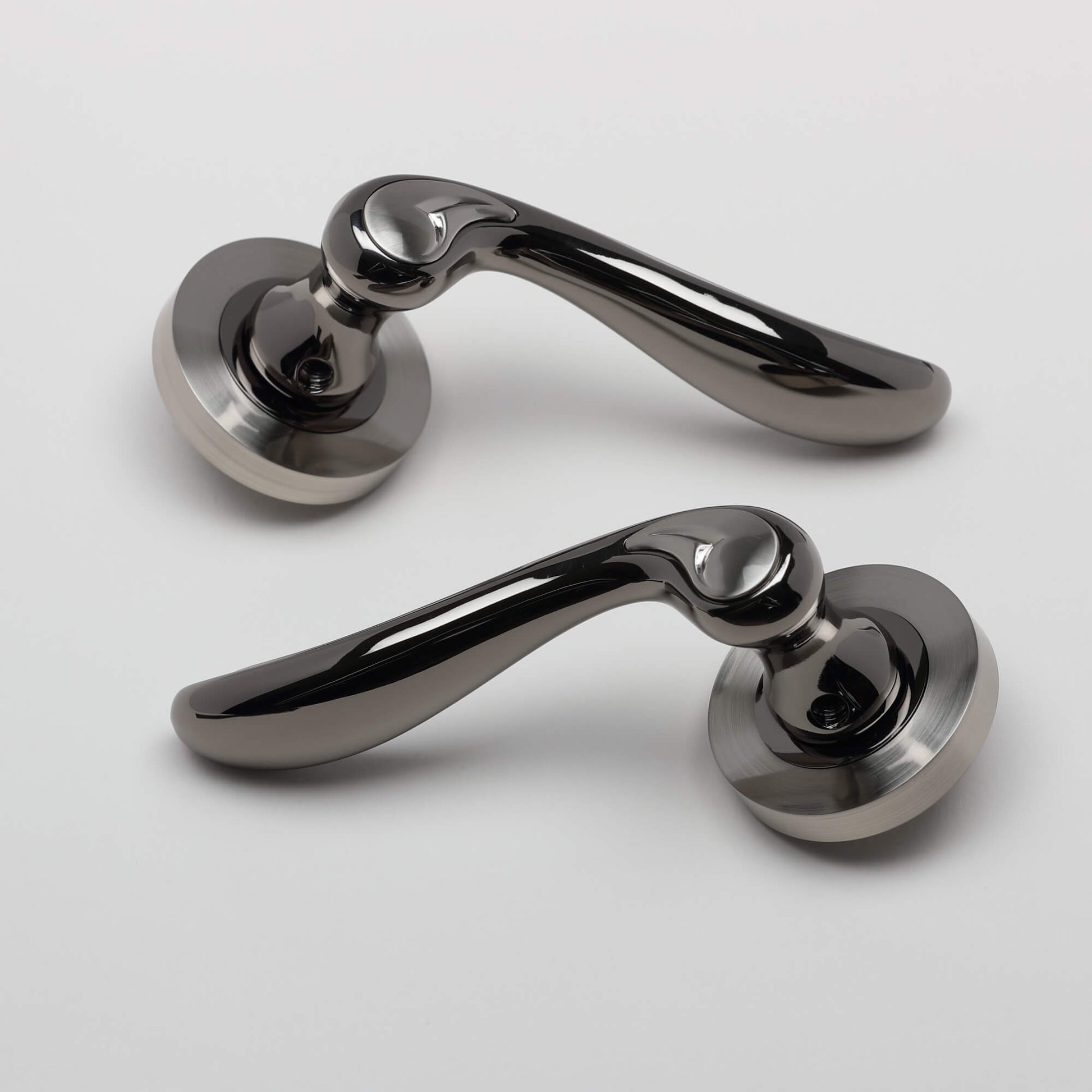 A pair of Monet Black Nickel & Nickel Brushed Round Rose Door Handle on a white background.