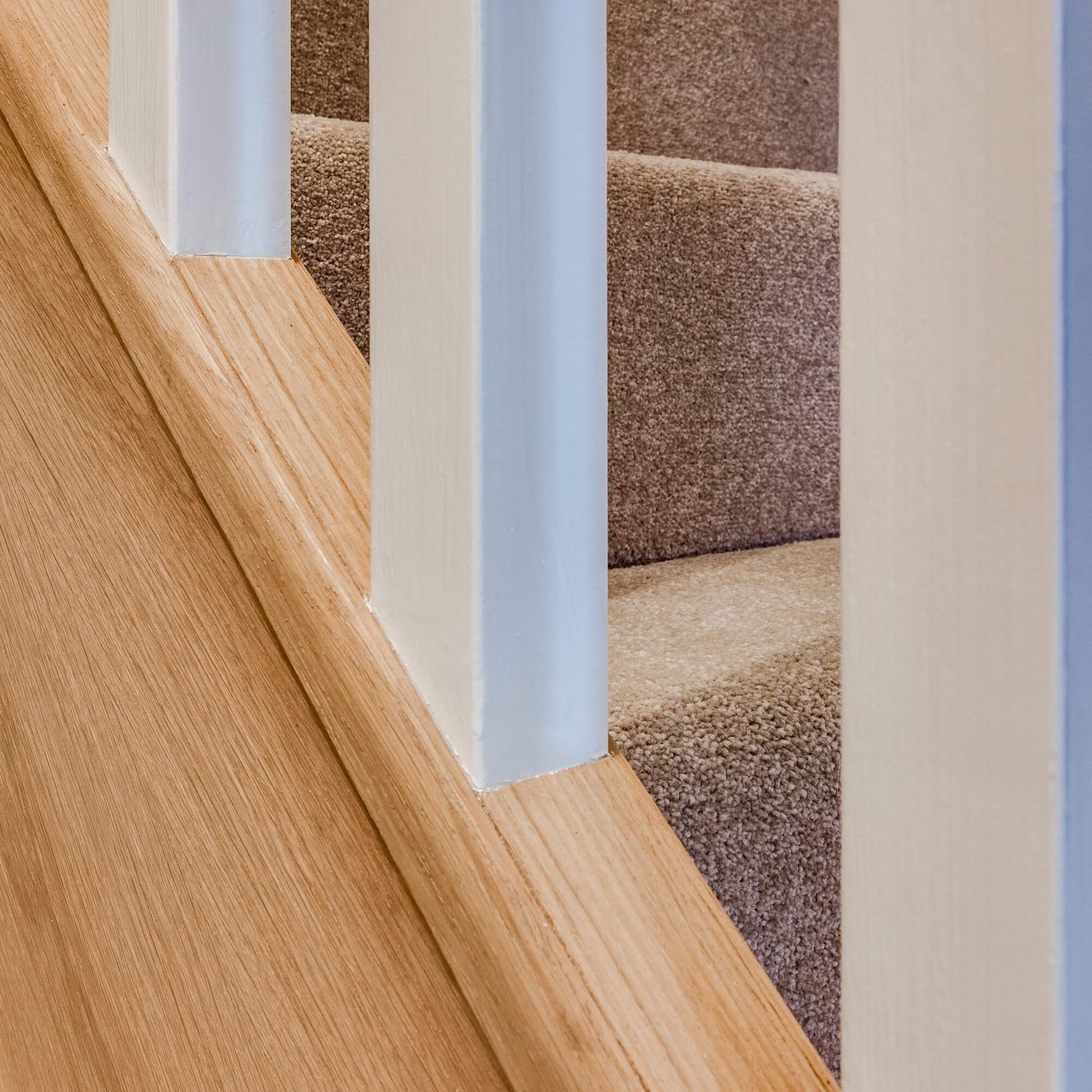 Close-up of an Oak Veneered (41mm Infill) Baserail on a set of stairs