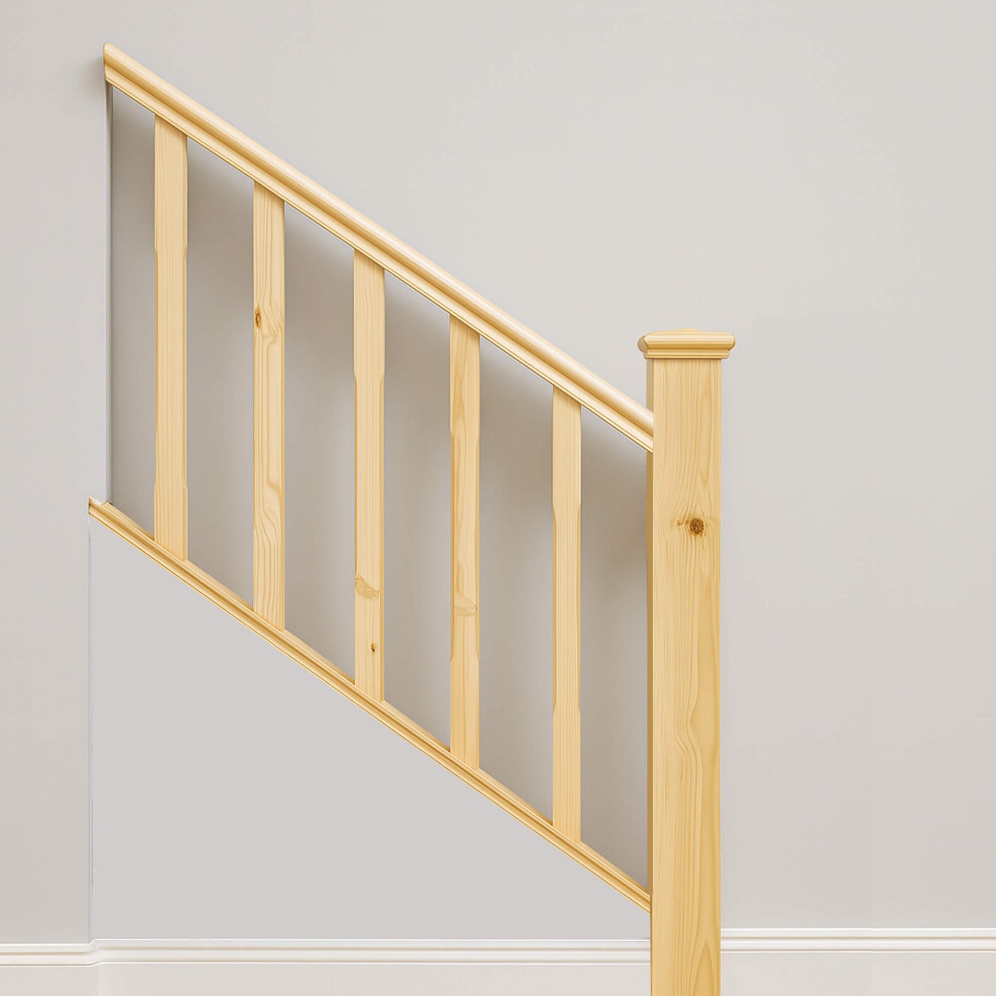 Wooden staircase railing with Redwood Pine Chamfered SpindleS against a plain wall.