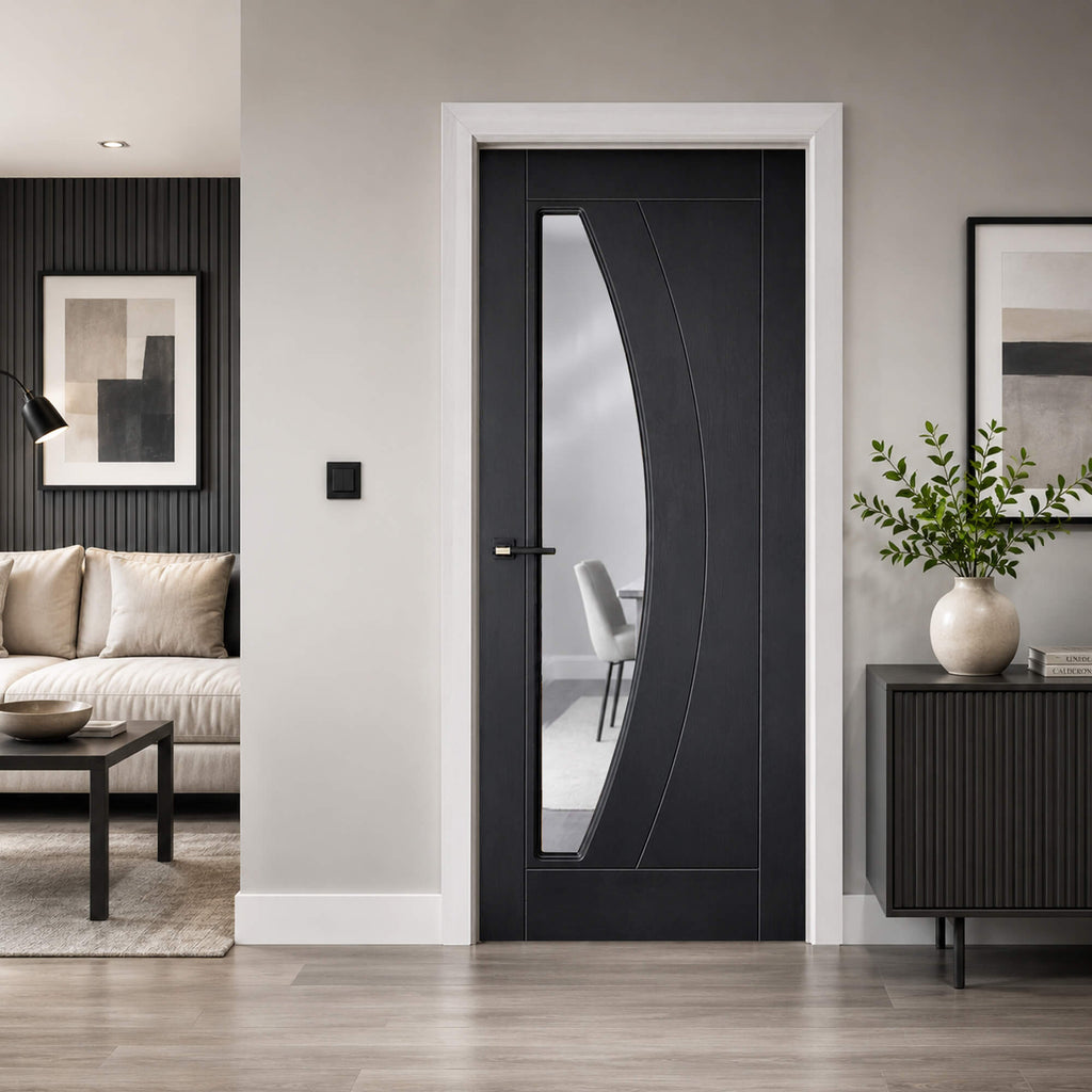 Modern Salerno Black Ash 35mm 1 lite laminate door with a living room in the background and a view of a dining room through the glass panel.