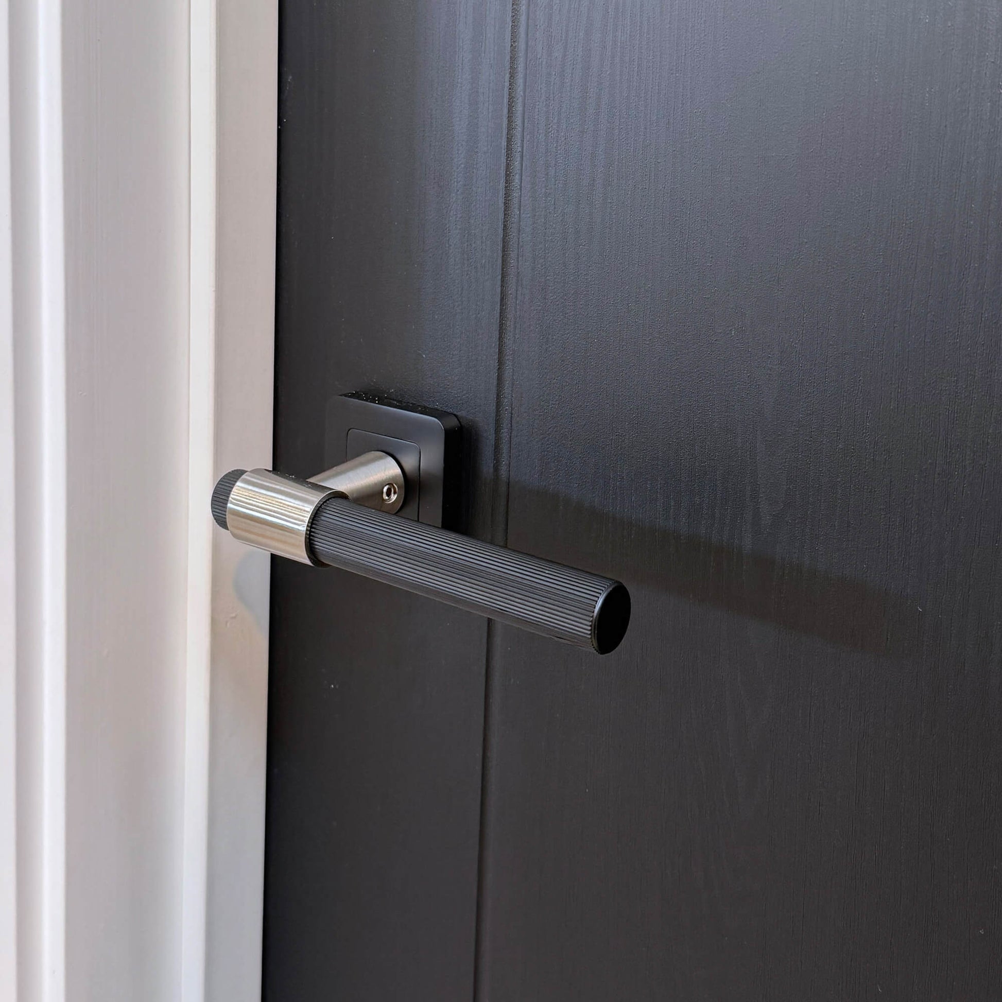 Close-up of a Salerno Black Ash 35mm Laminate Door with a Stratus square rose door handle.