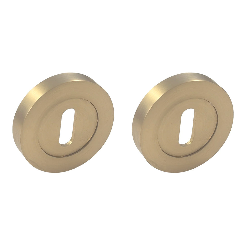 Satin brass escutcheon set for a mortice lock to match satin brass round rose handles on a white background
