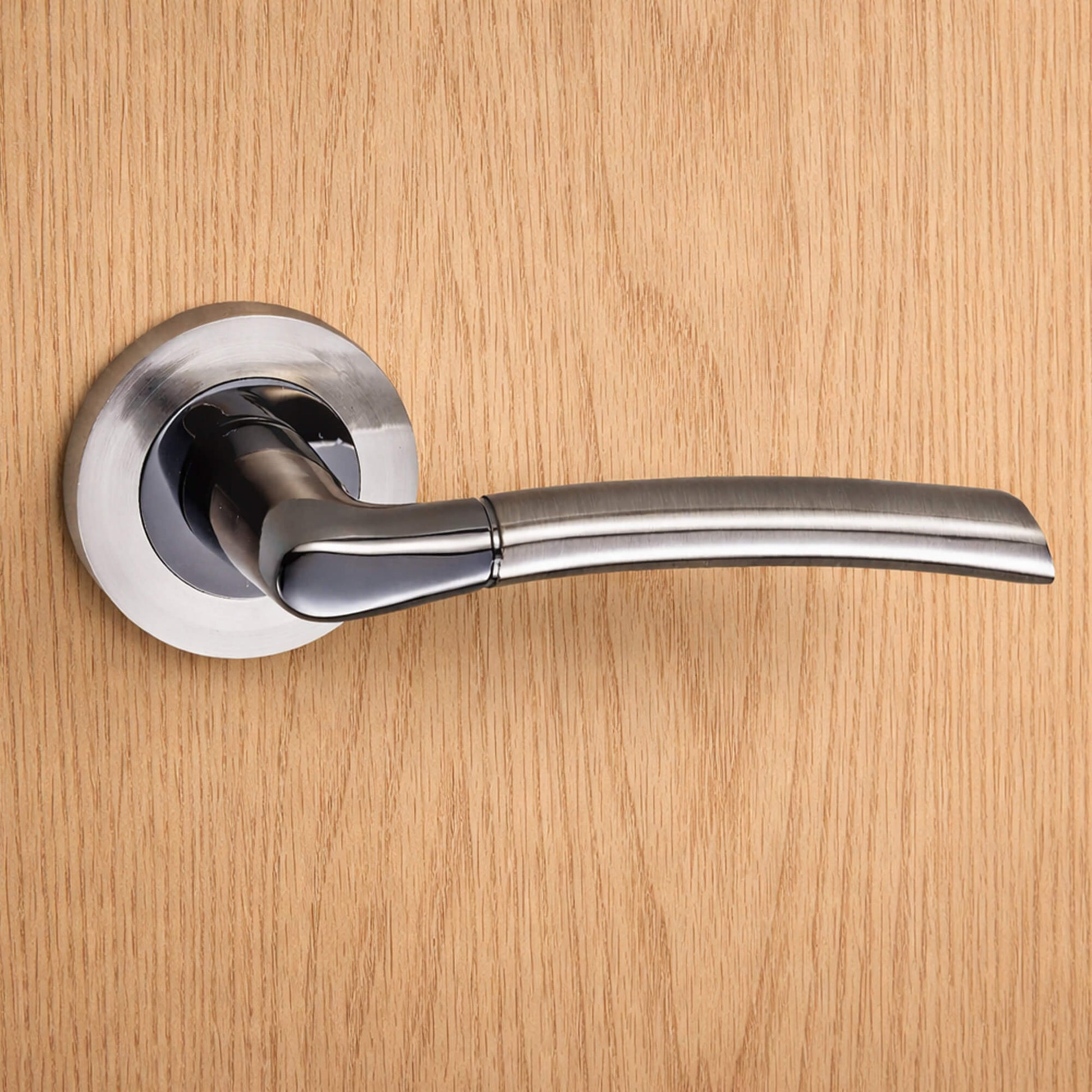 A Storm Black Nickel & Nickel Brushed Handle on a wooden door