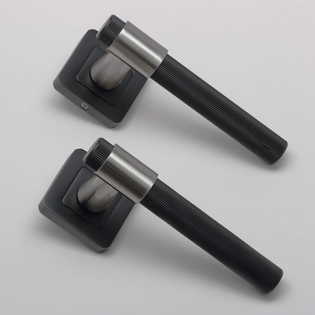 Angled view of a pair of A Stratus Flat Black & Nickel Brushed Square Rose Handle on a light grey background.