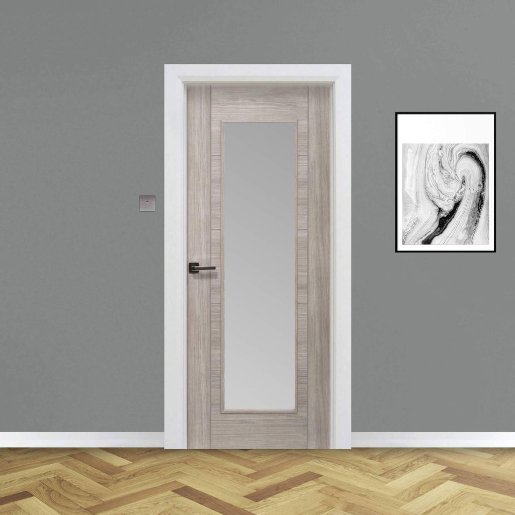 A Tigris Stone Grey 1 Lite Unglazed 40mm Internal Laminate Door, with 4mm sandblasted toughened glass and an Alto handle, in a home interior setting.