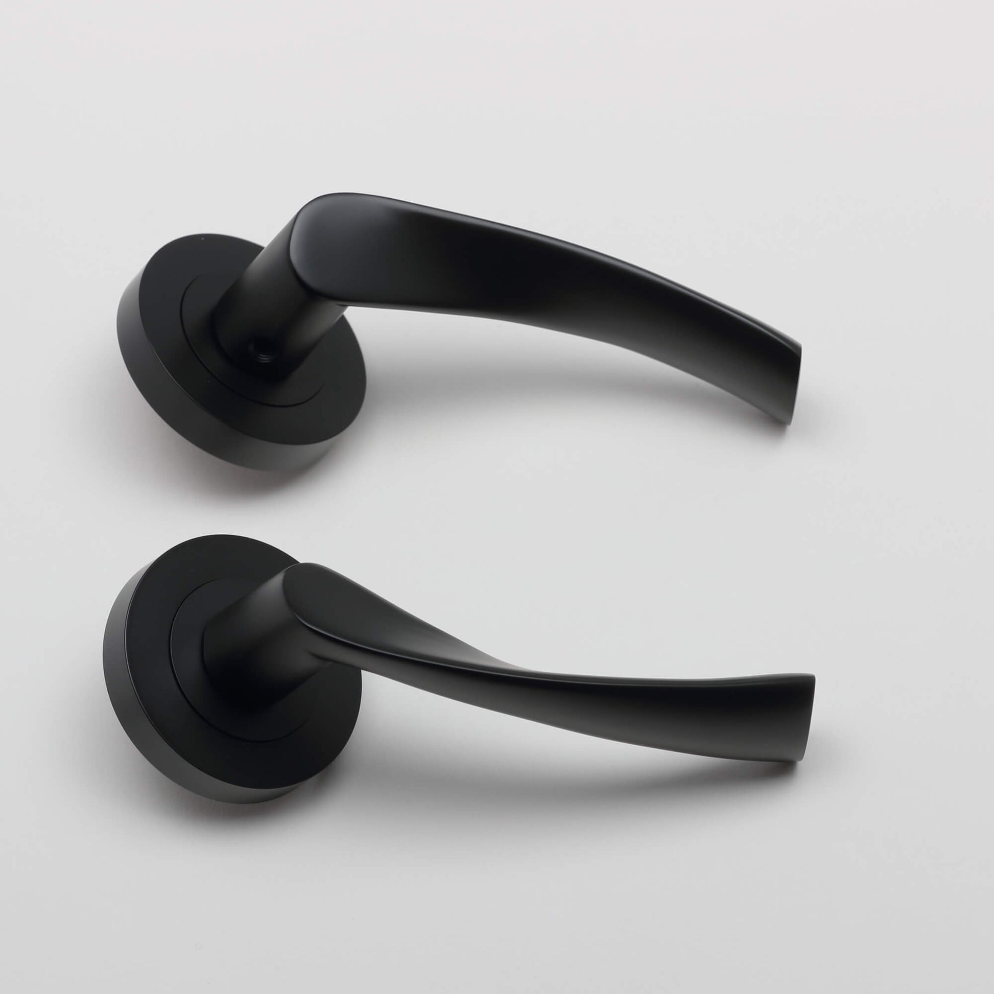 A side view of a pair of Trade Range Flat Black door handles on a white background.