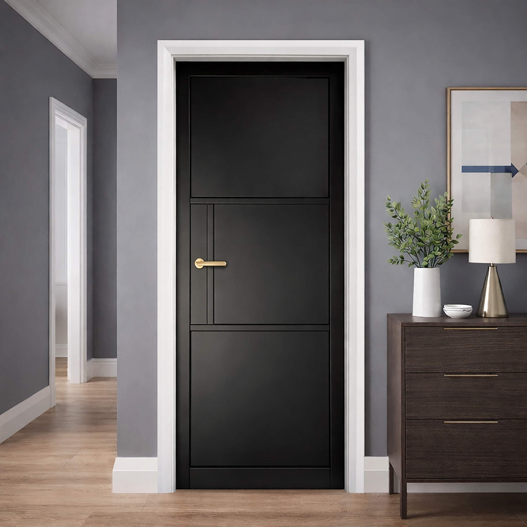 A Tribeca Black Primer Plus 3 Panel Internal 40mm Door with gold handle in a hallway setting with grey walls and wooden flooring.