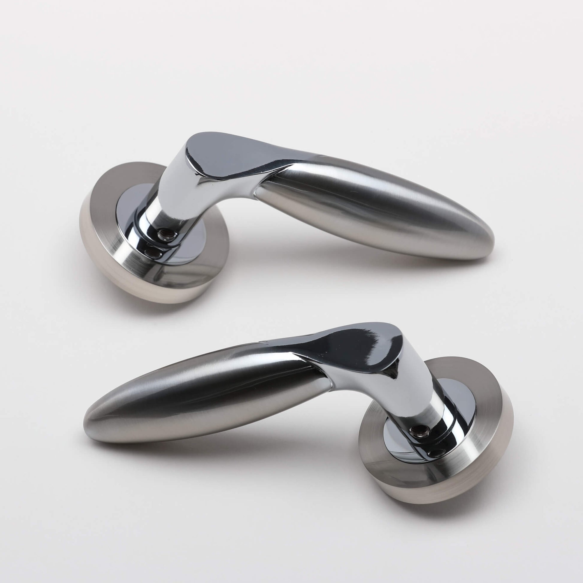 A set of Zeus Nickel Brushed & Polished Chrome Handles on a grey background.